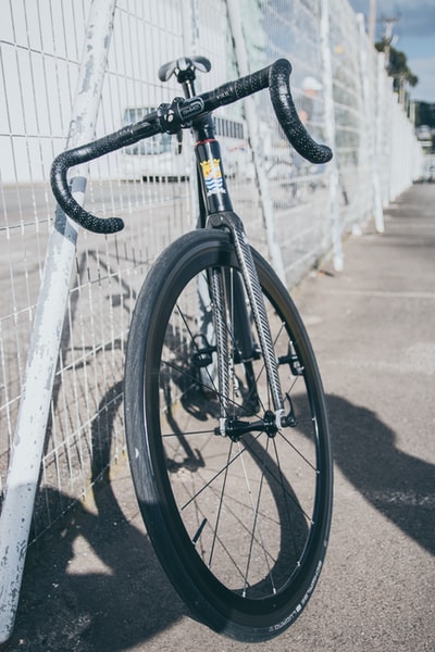 黑色和白色道路自行车停放的金属栅栏旁边
